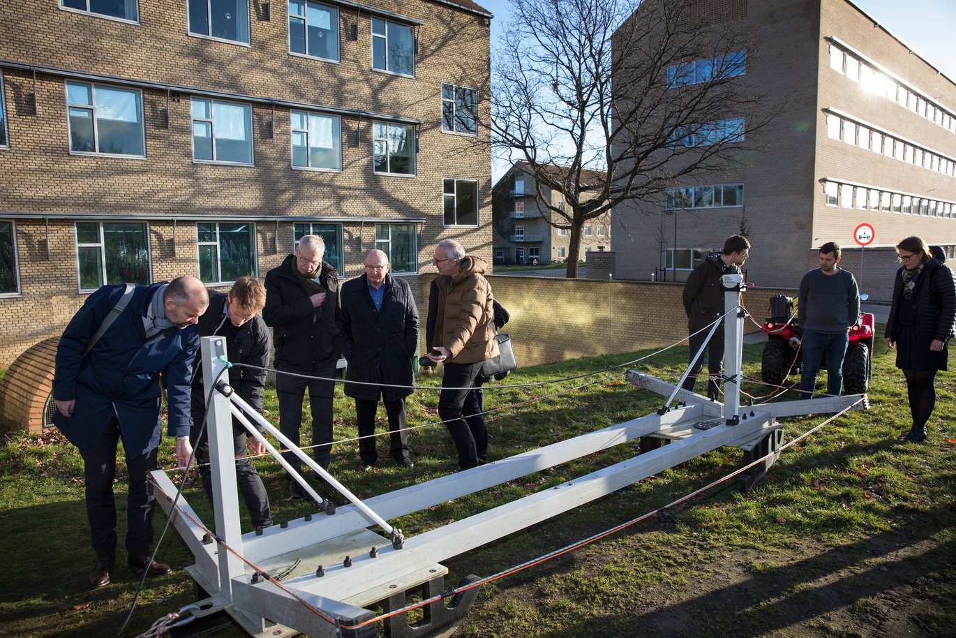 Esben Auken viser gæsterne en stor metalkonstruktion på plænen i universitetsparken.