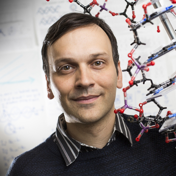 Portrætfoto af Ebbe S. Andersen med en plasticmodel af et molekyle.